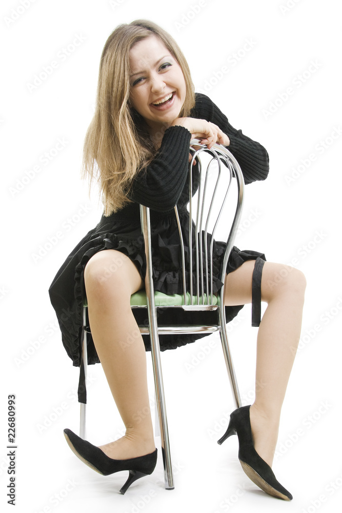 Fototapeta premium The cheerful woman sits astride a chair