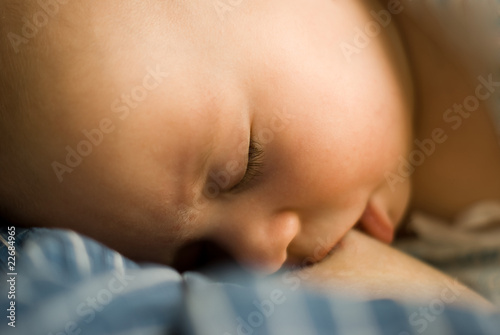 baby girl sleeps with mother's tit in her mouth photo