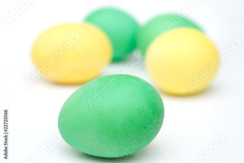 five yellow and green Easter eggs isolated on white