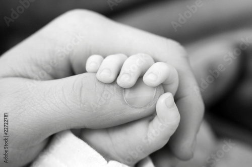 Baby hand holding on to father's finger