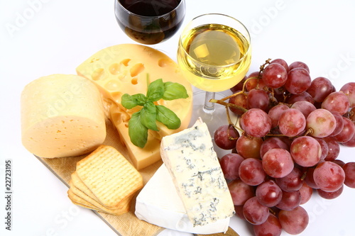 Various types of cheese, grapes, wine  and crackers