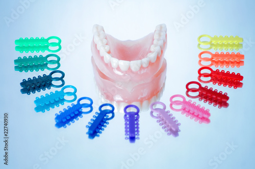 Canvas Print Dentures surrounded by multicolored orthodontic ligature ties