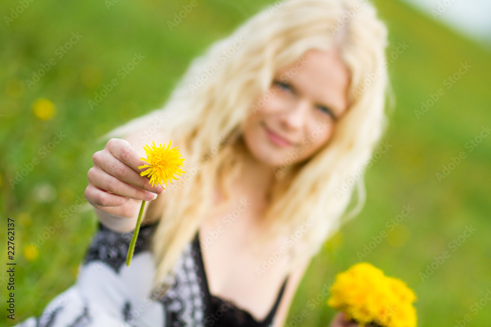 Young girl giving a dandelion on meadow Young girl giving a dandelion on meadow