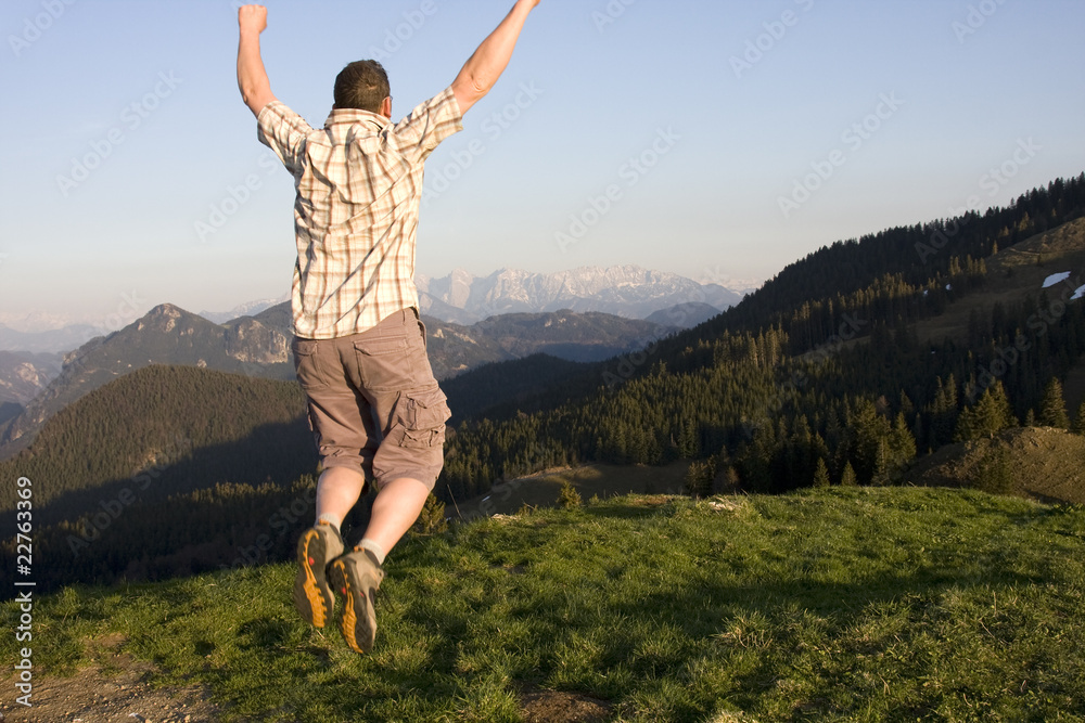 Fototapeta premium mann spring vor freude in den alpen
