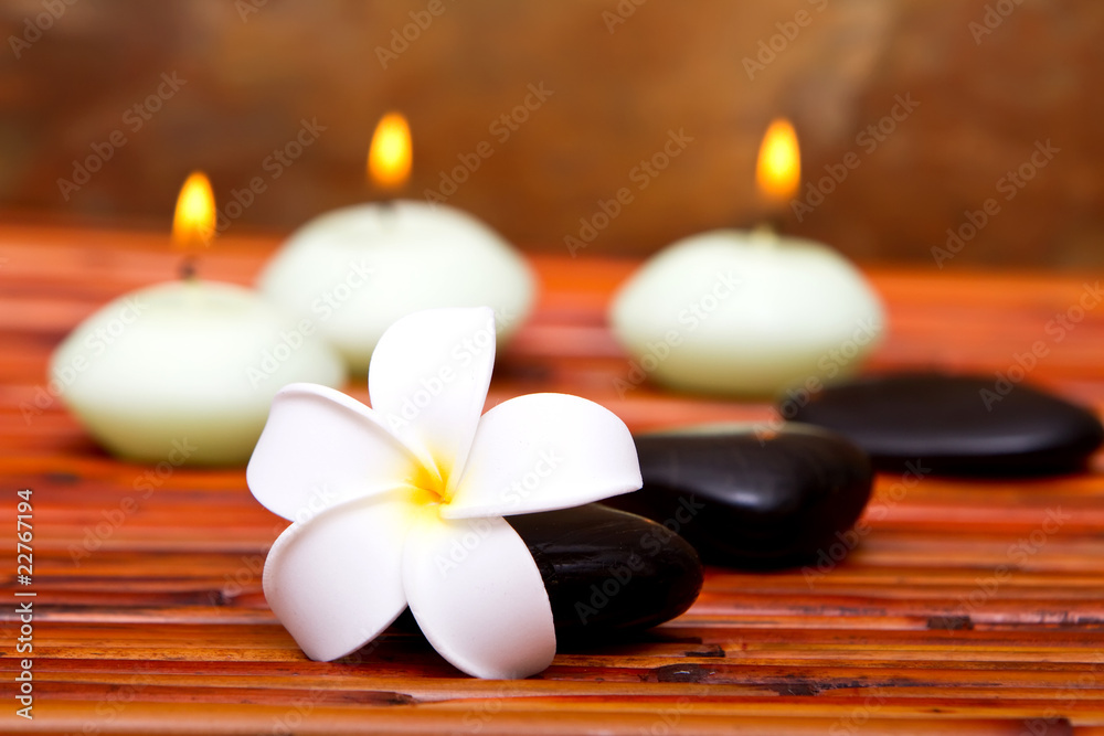 Spa stones, candles and frangipani flower
