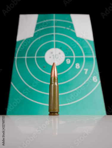 gun cartridge over target with bulletholes photo