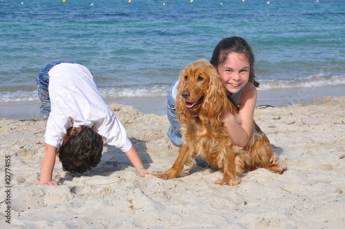 enfants et leur chien heureux sur la plage photo