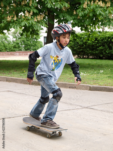 Junge fährt skateboard mit Helm, Knieschützern & Ellenbogenschutz