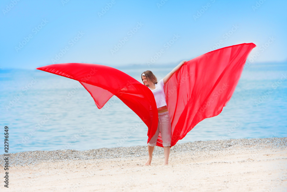young happy girl with red wings on sea background