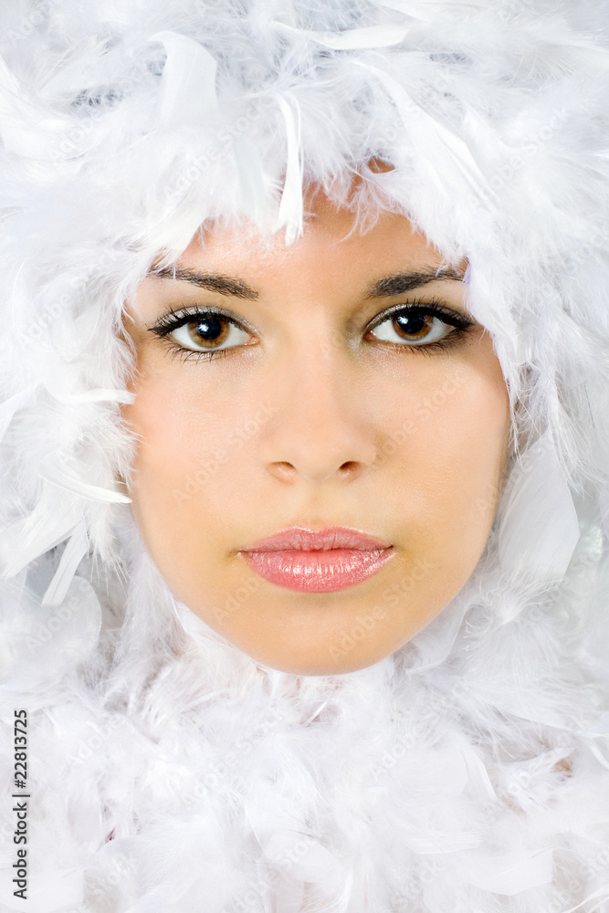 Beautiful portrait of young woman surrounded by feathers