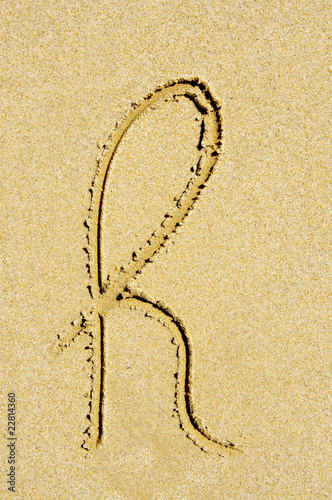 h letter written in the sand on a beach