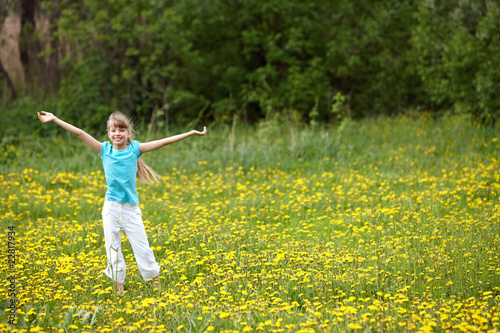 Child on meadow with hand up.