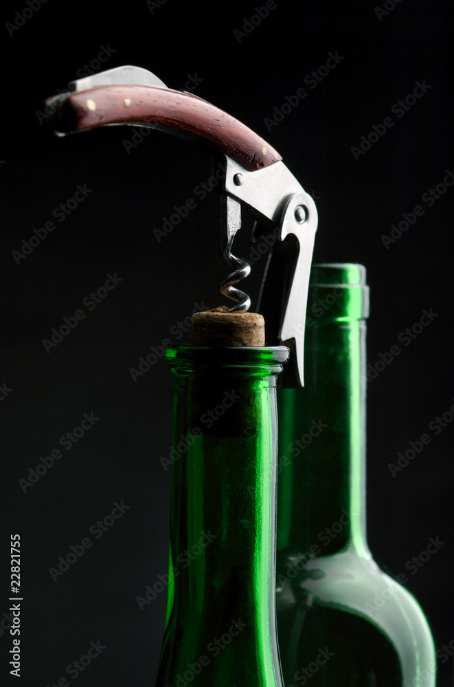 Corkscrew and bottle with a fuse on a dark background Corkscrew and bottle with a fuse on a dark background