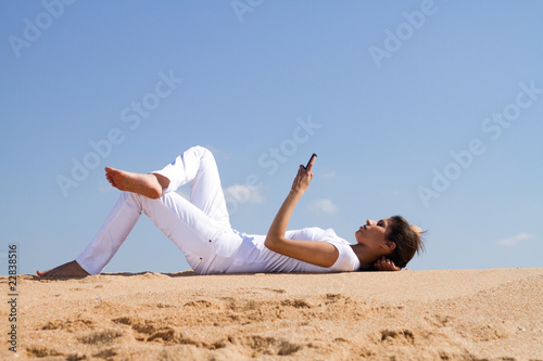 young woman on beach reading book