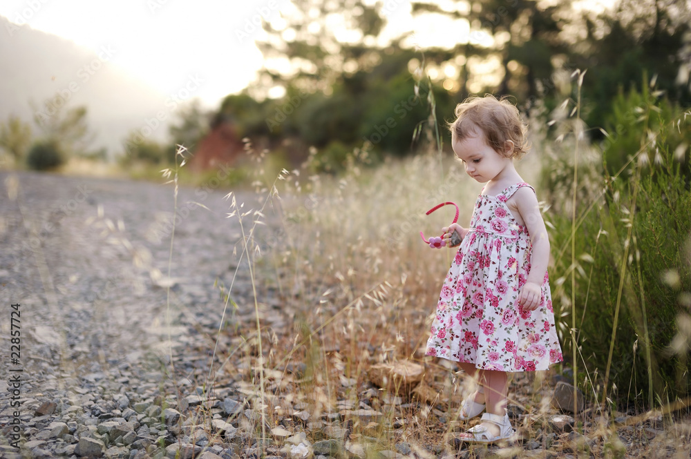 Adorable toddler girl in a floral dress Adorable toddler girl in a floral dress