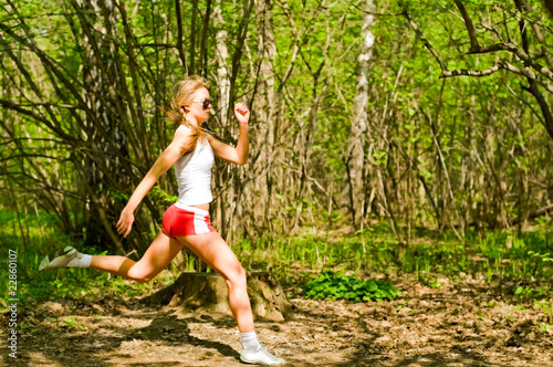 young woman running in forest