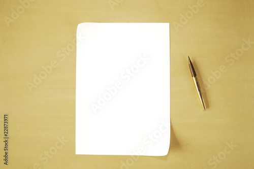 A plain piece of paper and pen against a plain background
