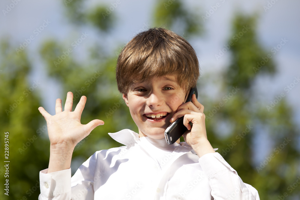 Achtjähriger mit Mobiltelefon hebt seine Hand