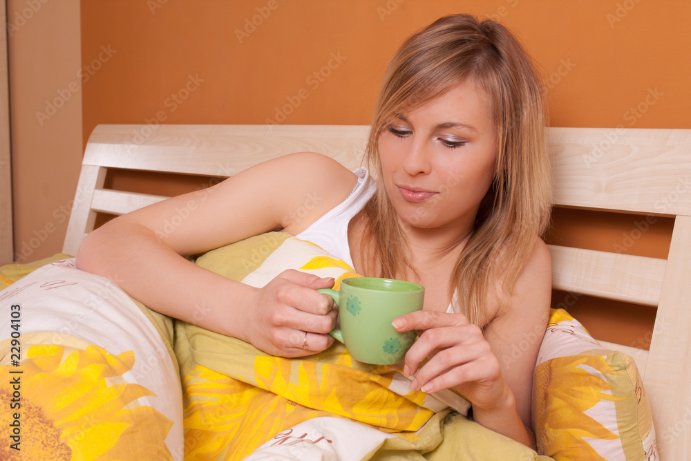 Bautiful woman with cup of coffee or tea at bedroom on bed - obrazy, fototapety, plakaty 