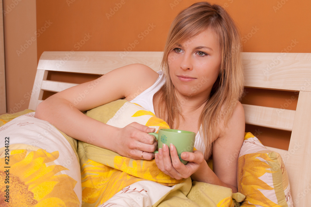 Bautiful woman with cup of coffee or tea at bedroom on bed - obrazy, fototapety, plakaty 