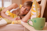 A cup of cofee or tea at bedroom, in background sleeps woman