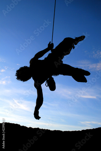 silhouette d'un grimpeur : descente en rappel photo