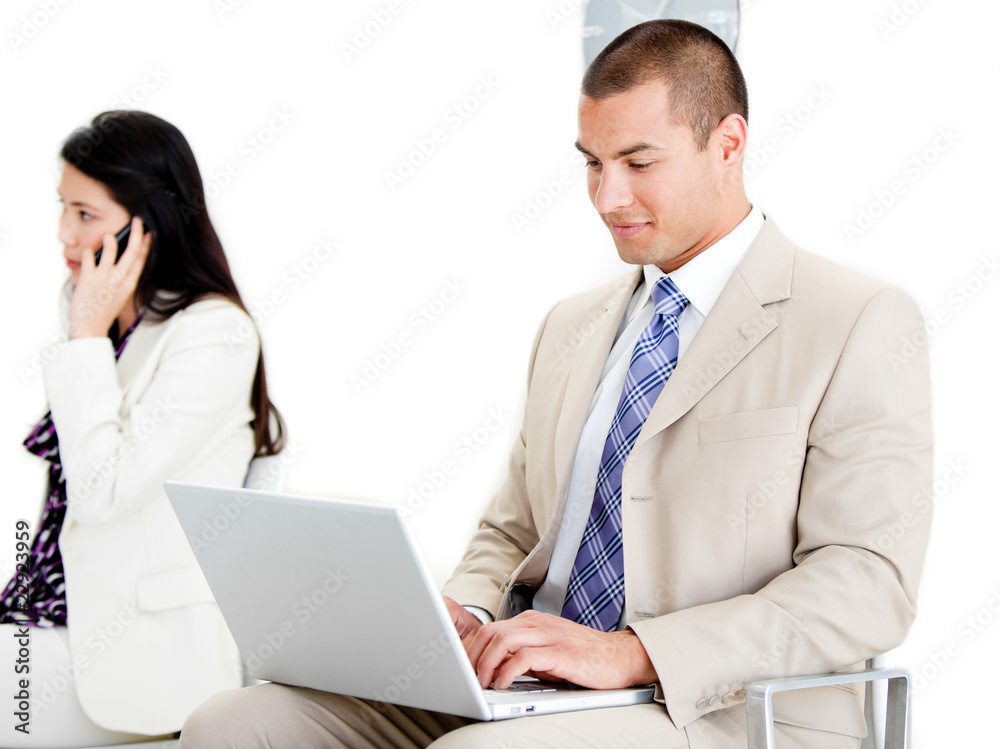 Young businessman using a laptop in a waiting room Young businessman using a laptop in a waiting room