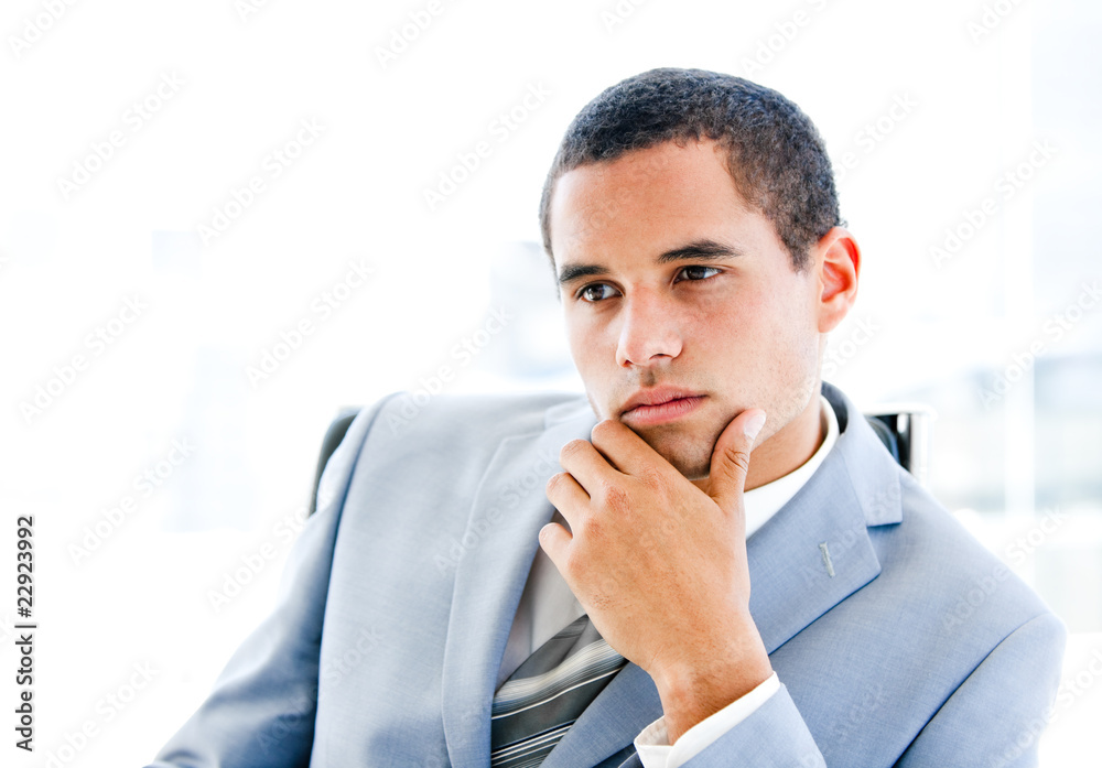 Portrait of a pensive young businessman sitting at his desk Portrait of a pensive young businessman sitting at his desk