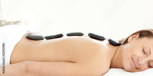 Charming woman with hot stones on her back