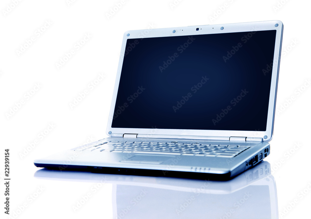 Modern laptop with reflections on glass table.. Modern laptop with reflections on glass table..