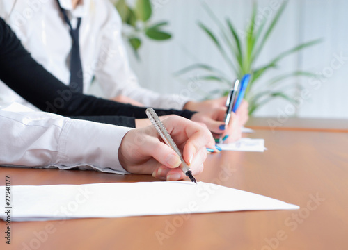 person's hand signing an important document