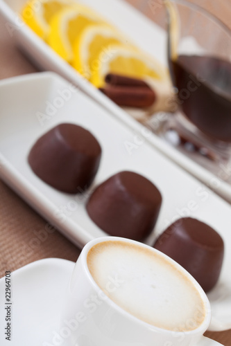 Coffee cup, chocolates plat and tea with lemmon