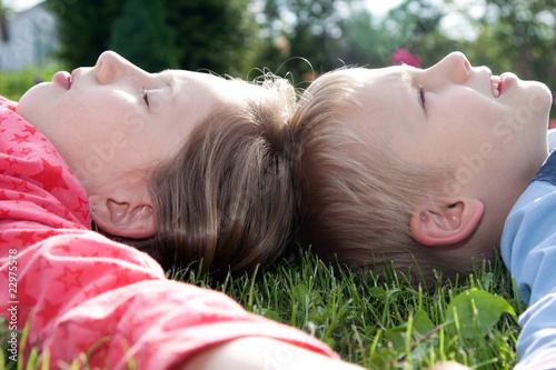 Chłopiec i dziewczynka leżą na trawie
