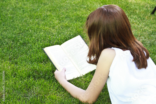 Young beautiful girl reading a book outdoor