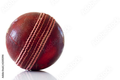 Old red leather cricket ball isolated against a white background