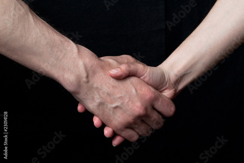 A male hand shaking hands with a female hand