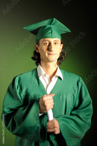portrait of a happy succesful man on his graduation day in green