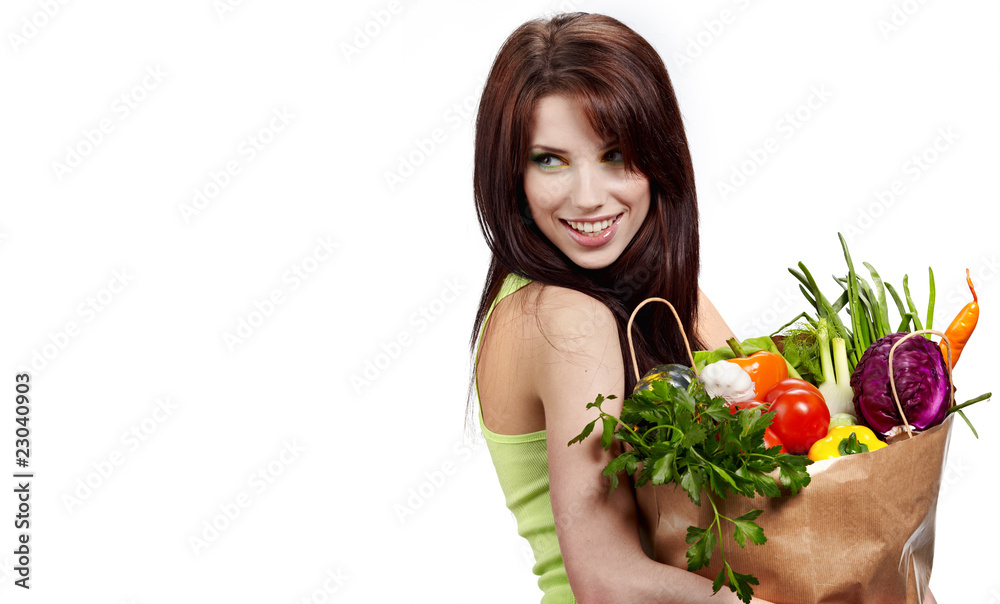 Woman with a shopping bag filled with nutritious fruit and veget Woman with a shopping bag filled with nutritious fruit and veget