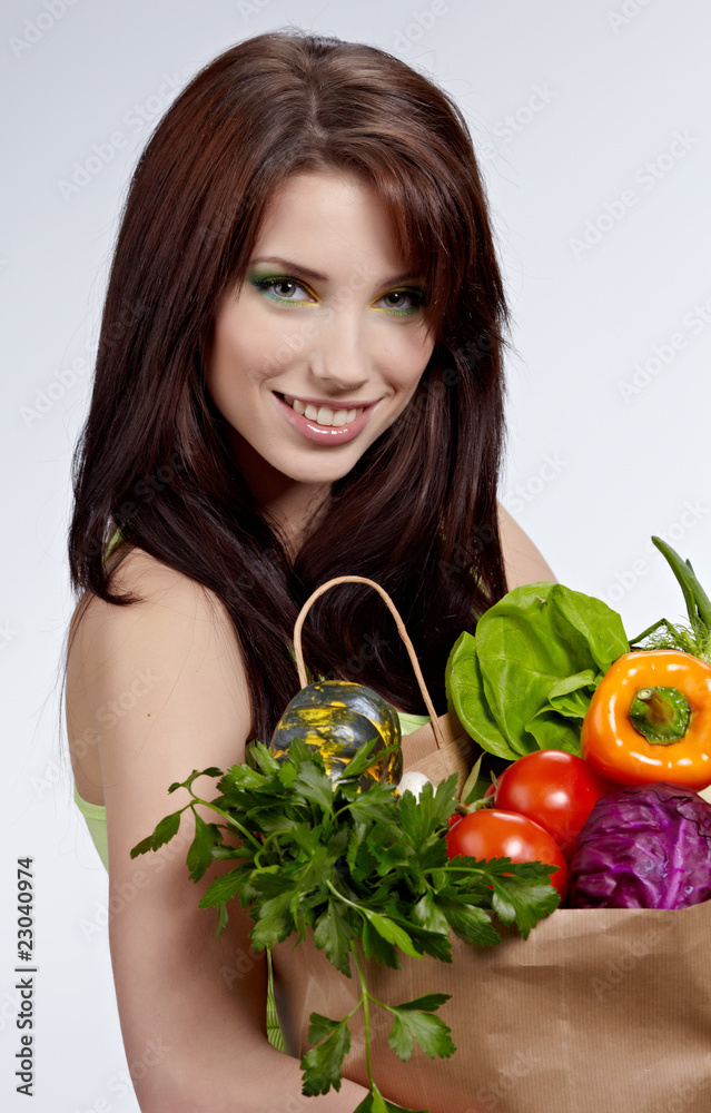 Woman with a shopping bag filled with nutritious fruit and veget Woman with a shopping bag filled with nutritious fruit and veget