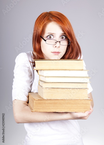 Red-haired businesswoman keep books in hand.