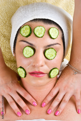 Woman with cucumber mask getting neck massage