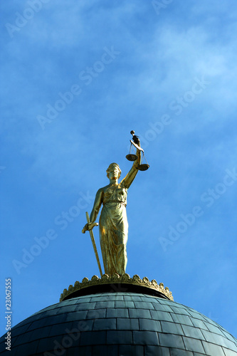 Lady Justice statue against blue sky
