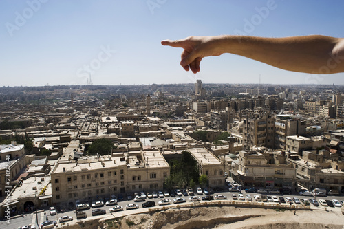 Man pointing to the infinite over the city of Aleppo, Syria