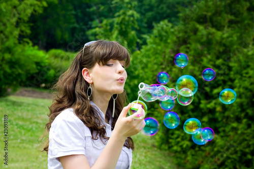 smile teen with soap bubbles in vivid green spring forest park