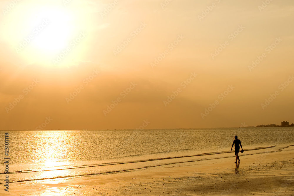 Man strolling along the waves at Fort Myers Beach, Florida