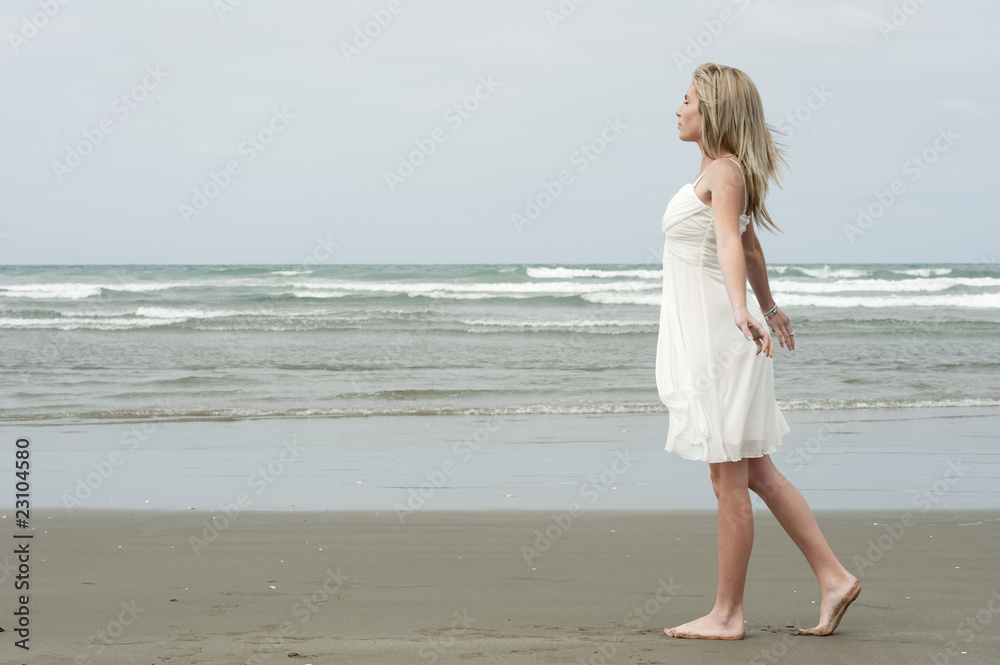 beautiful teenage girl walking peacefully at beach