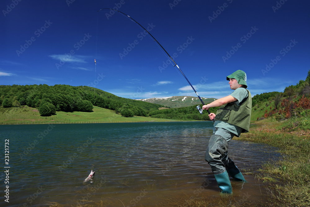A fisherman fishing on a Mavrovo lake, Macedonia A fisherman fishing on a Mavrovo lake, Macedonia
