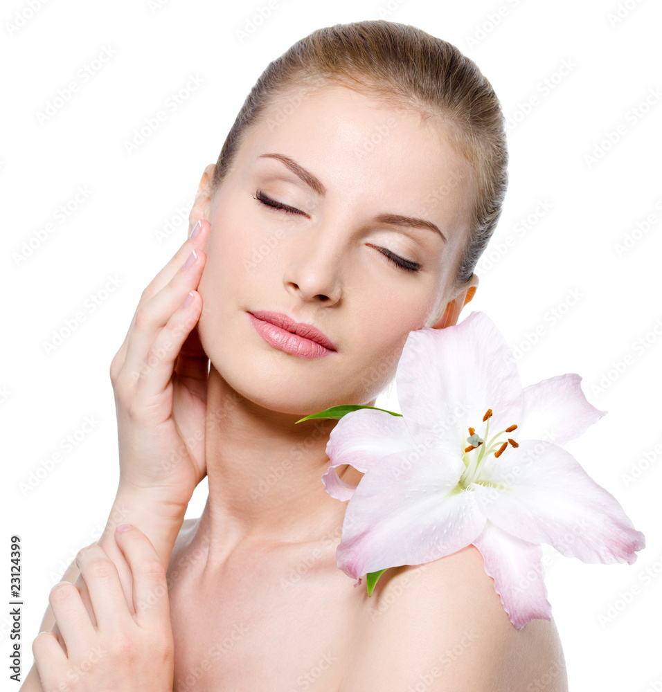 Woman with closed eyes and with lily stroking her face Woman with closed eyes and with lily stroking her face