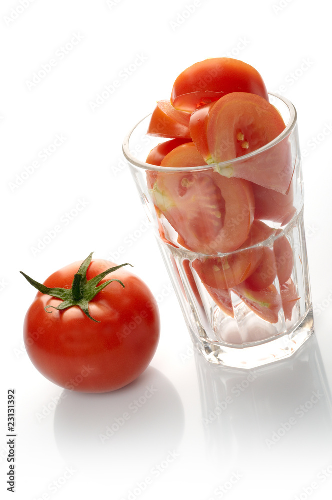 Tomato and slices in glass isolated on white background Tomato and slices in glass isolated on white background
