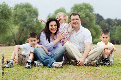 Portrait of happy family of five on the green land